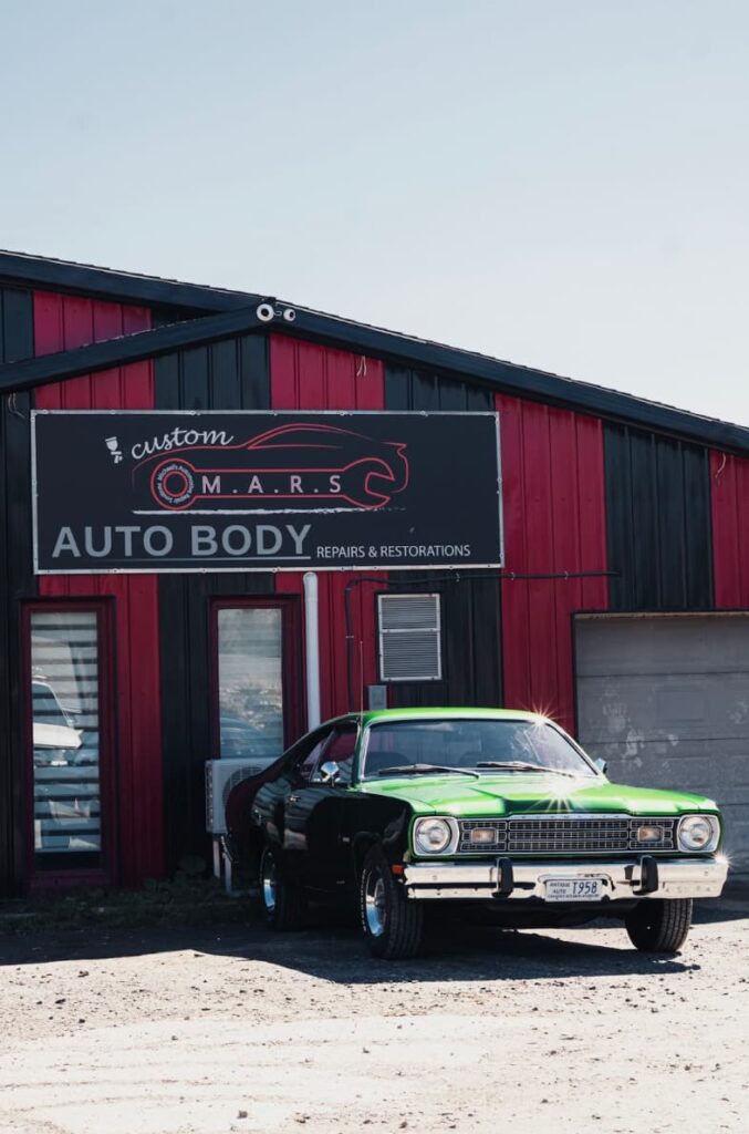 Vintage American green muscle car photographed outside a restoration garage in Nova Scotia.