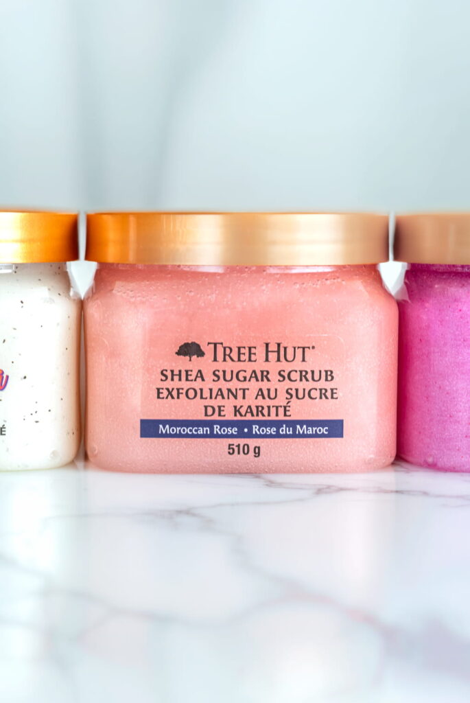 Professional product photography featuring multiple Tree Hut body scrub containers for commercial branding.