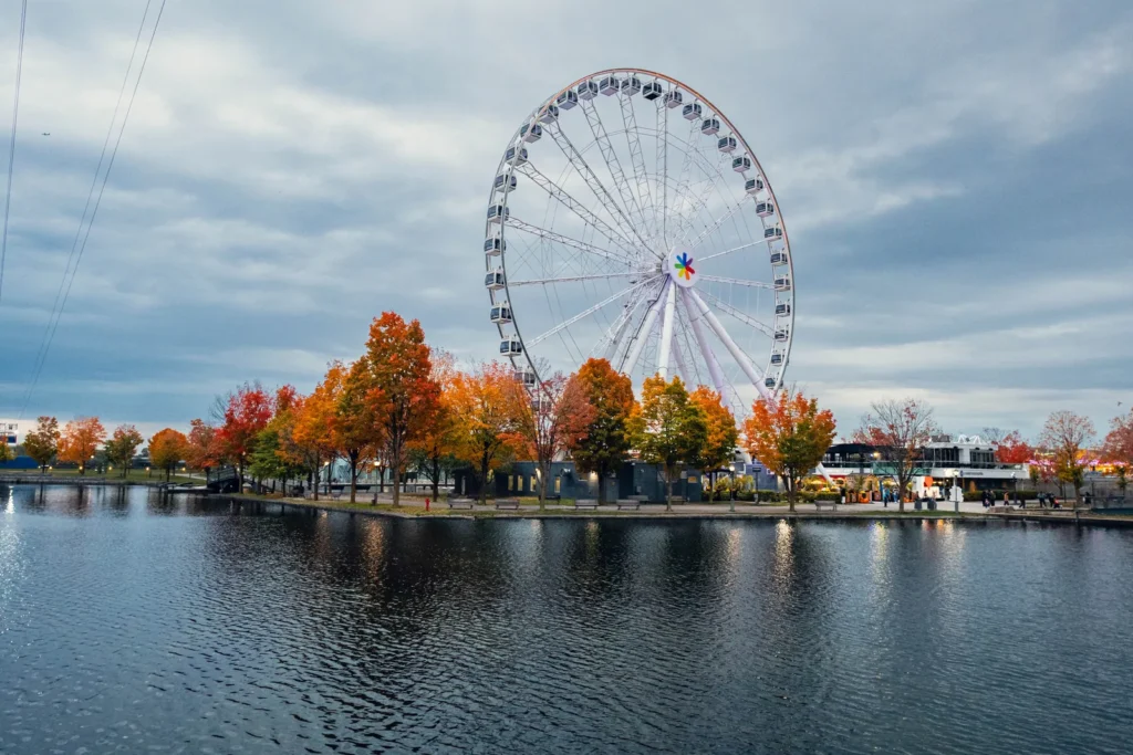 Old Port of Montreal Ferris wheel behind orange autumn trees along the waterfront