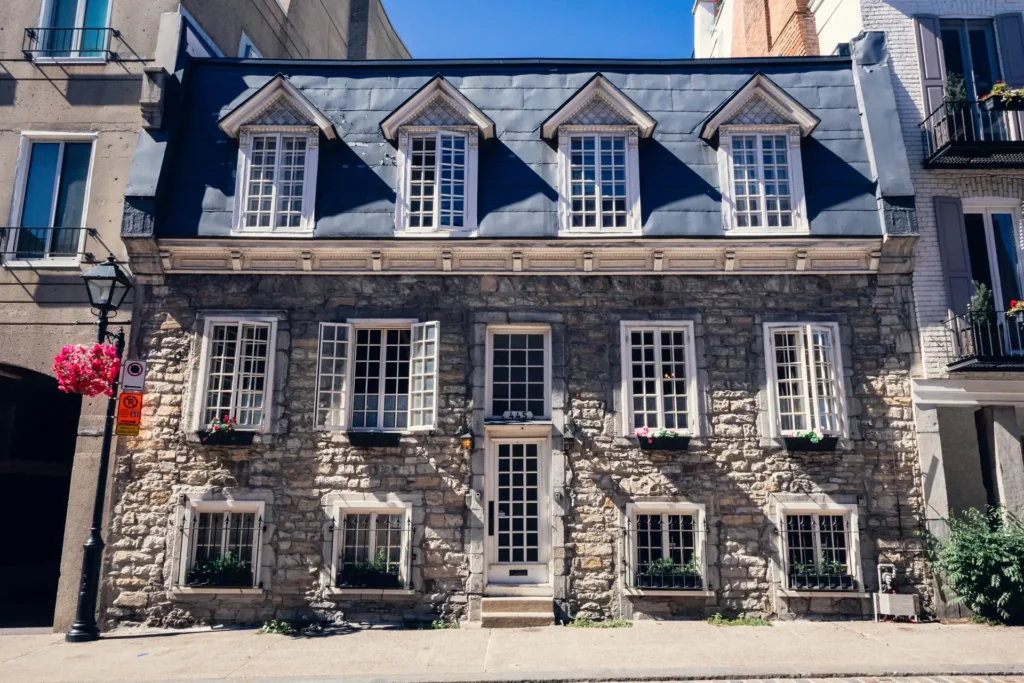 Historic stone building with dormer windows in Old Montreal on a sunny day.
