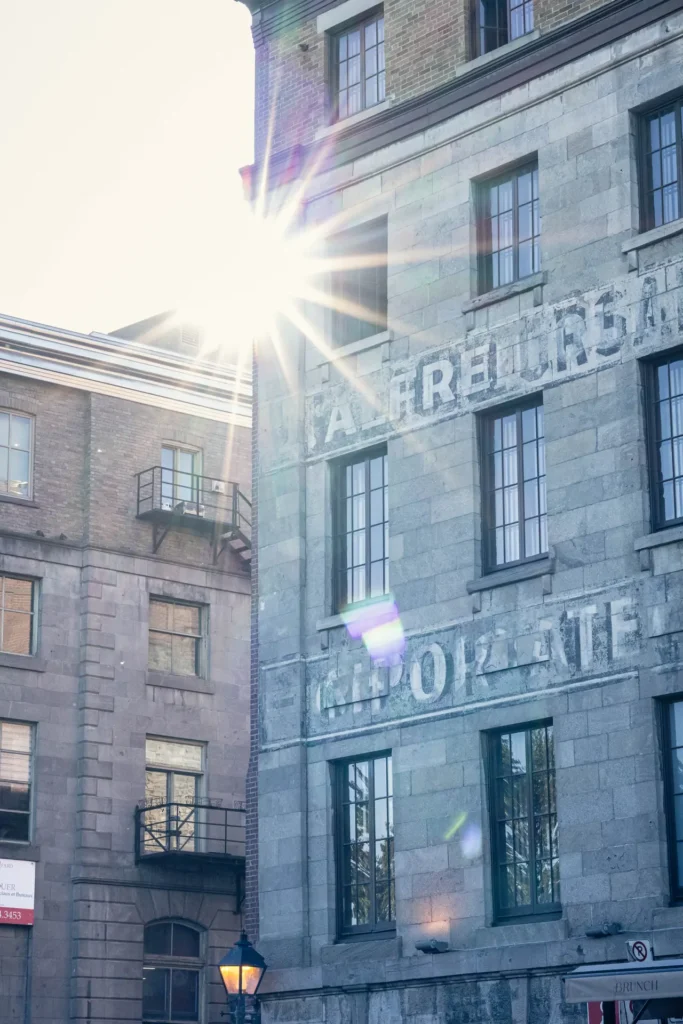 Sunlight shining between historic stone buildings in Old Montreal.